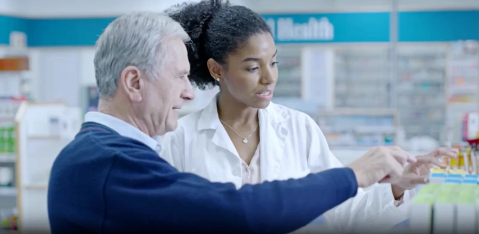 A community pharmacist helping a member choose a medication
